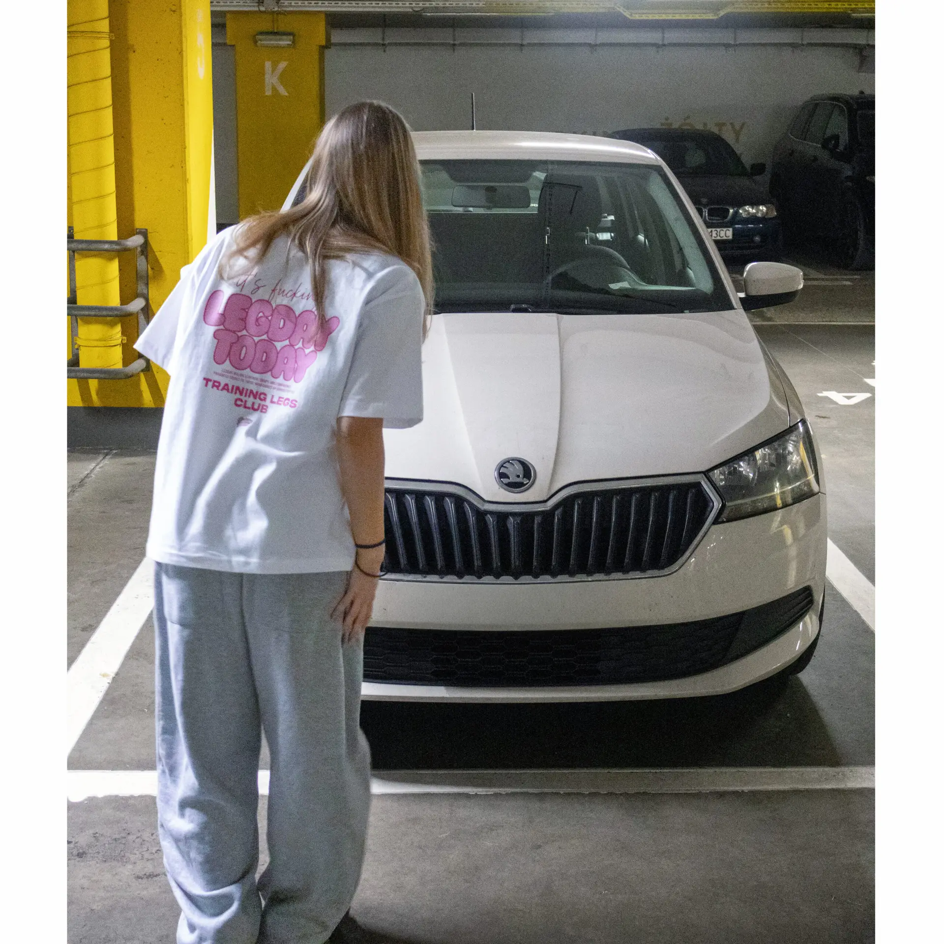 damska koszulka oversize z różowym nadrukiem Legday Today w miejskim parkingowym klimacie